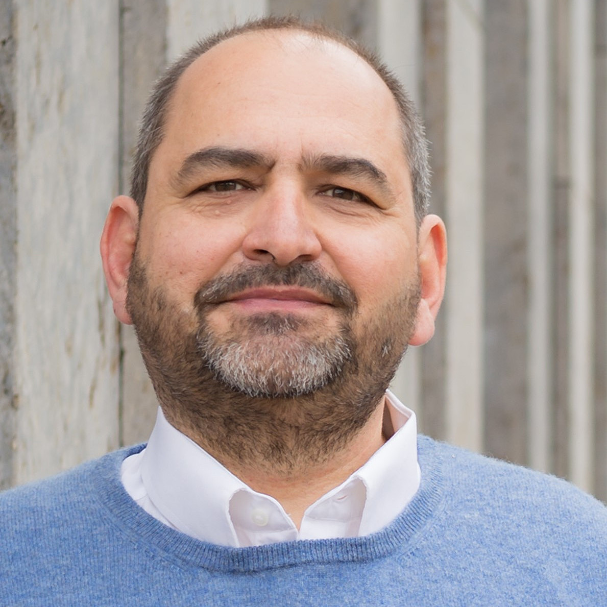 Portraitfoto von Dr. Andreas Pirsing. Er trägt einen blauen Pullover und schaut direkt in die Kamera.